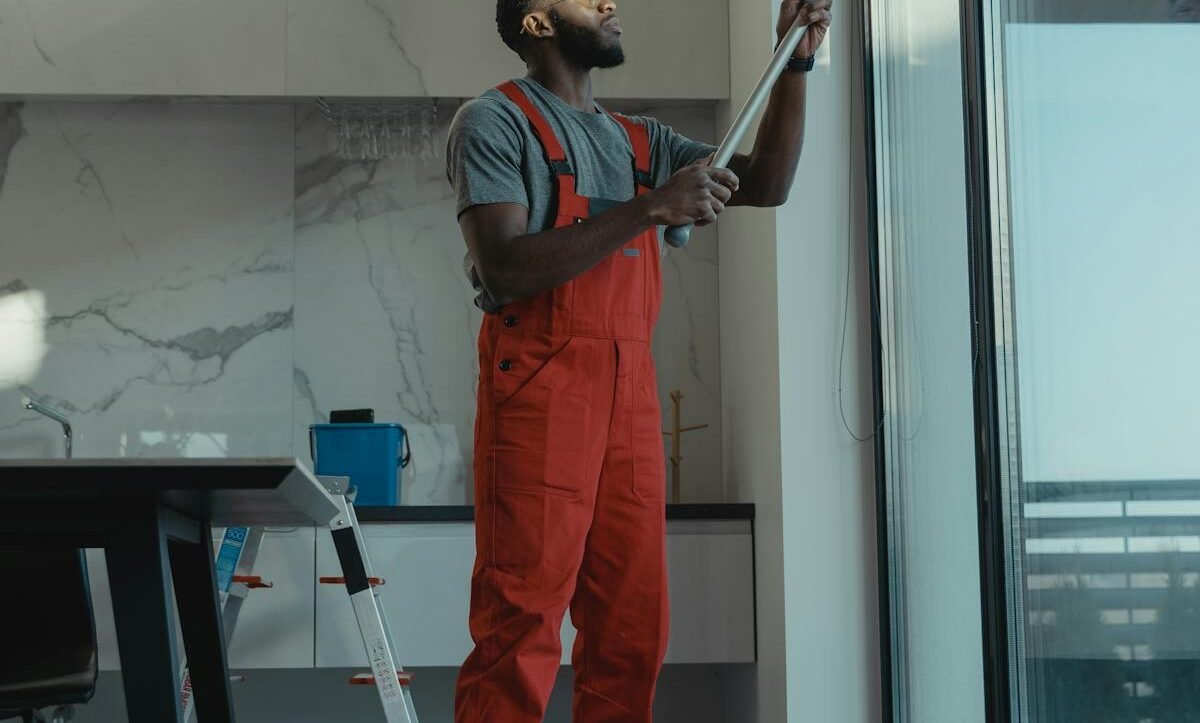 Professional using water-fed pole to clean a large interior window streak-free