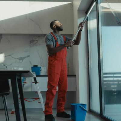 Professional using water-fed pole to clean a large interior window streak-free