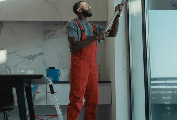 Professional using water-fed pole to clean a large interior window streak-free