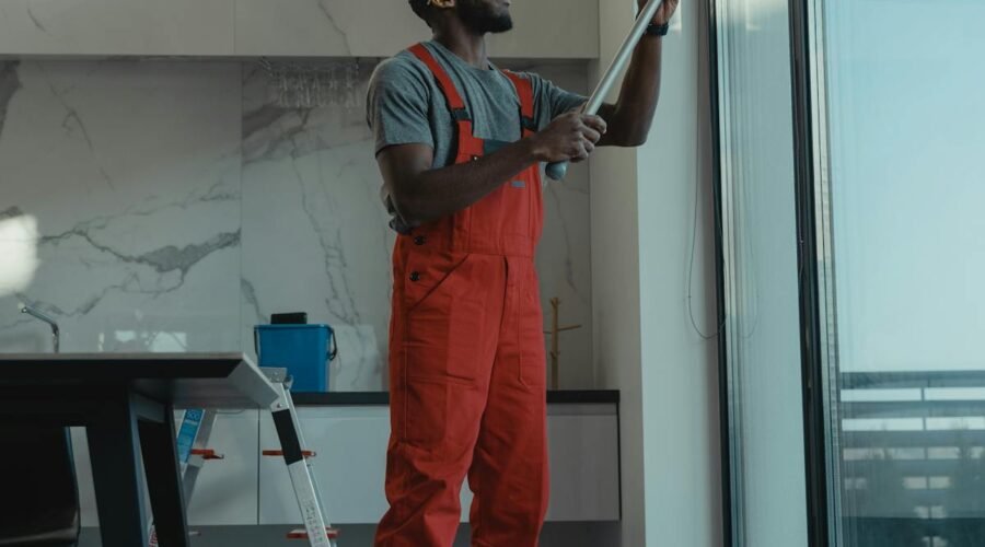 Professional using water-fed pole to clean a large interior window streak-free