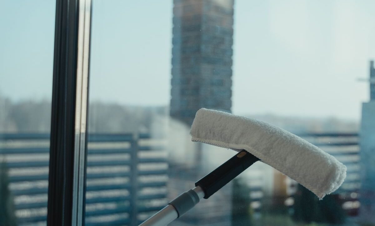 Water-fed pole brush head pressed against a clean glass window for purified water window cleaning