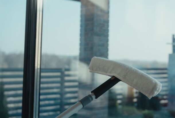 Water-fed pole brush head pressed against a clean glass window for purified water window cleaning