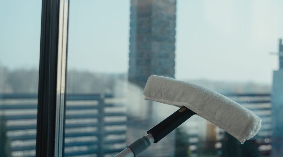 Water-fed pole brush head pressed against a clean glass window for purified water window cleaning
