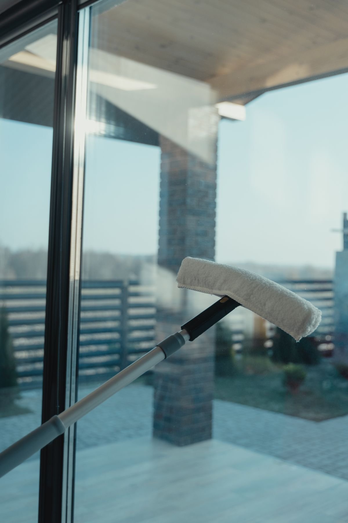 Water-fed pole brush head pressed against a clean glass window for purified water window cleaning