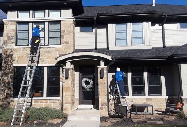 Professional window washing in Chicago suburbs - two Ernest Windows technicians cleaning a stone home