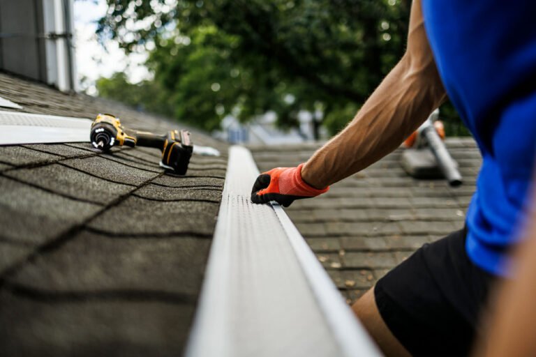 Ernest Windows technician installing gutter guards on a Chicago area roof